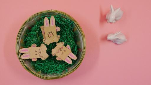 Hüpfende Osterhasen | Rechte: KiKA drei Osterhasen aus Papierrollen in einem Osternest, daneben sitzen zwei Hasen aus Porzellan