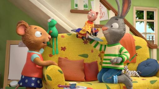 Der fliegende Schweinchen-Wagen | Rechte: © Magic Light Pictures LTD 2023 Posy, die Maus hält ihr Lieblingsspielzeug, das Stofftier Froschi in Höhe der Sofalehne und sagt etwas zu Pip. Pip, das Kaninchen, kniet seitlich auf dem Sofa und spielt mit einem selbst gebauten, fliegenden Schweinchen-Wagen. Sein Lieblingsstofftier Schweinchen sitzt auf dem fliegenden Wagen obenauf.