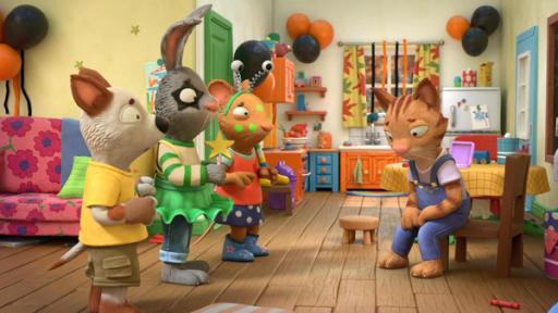 Frankie Frankenstein | Rechte: © Magic Light Pictures LTD 2023 In einem offenen Wohn-Esszimmer, das mit schwarzen und orangefarbenen Luftballons geschmückt ist, stehen die drei Freunde Zac, der Hund, Pip, das Kaninchen und Posy, die Maus betreten schauend vor ihrer Freundin Frankie. Die Katze Frankie sitzt auf einem Stuhl und blickt traurig mit hängenden Schultern nach unten. Während alle anderen kostümiert und geschminkt sind, hat Frankie weder ein Kostüm noch Schminke.