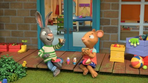 Kresseköpfchen | Rechte: © Magic Light Pictures LTD 2023 Auf der Holzterrasse vor dem Haus sitzen die beiden Freunde Pip, das Kaninchen und Posy, die Maus glücklich zusammen und genießen ihre Brotzeit. Pip hebt eins der schräg geschnittenen und belegten Brotscheiben nach oben. Posy hält ihr diagonal durchgeschnittenes, belegtes Brot in der Hand. Zwischen Pip und Posy stehen zwei Eierbecher in denen mit lustigen Gesichtern bemalte Eier sind, aus denen oben Watte hervorschaut und ein wenig Kresse.
