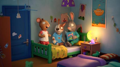 Zac kann nicht einschlafen | Rechte: © Magic Light Pictures LTD 2023 Abends im Zimmer während einer Übernachtungsparty: Die drei Freunde Posy, die Maus, Zac, der Hund und Pip, das Kaninchen haben es sich gemeinsam auf einem Bett gemütlich gemacht. Pip liest eine Geschichte aus einem Buch vor. Zwei Gästebetten aus Luftpolstermatratzen liegen im Zimmer auf dem Boden. Auf dem Nachttisch leuchtet ein Mond als Nachttischlampe.