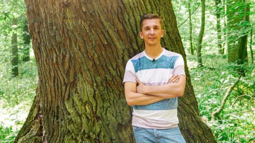 PUR+ - Teaser - Bäume retten Leben | Rechte: ZDF PUR+ Moderator Eric Mayer steht mit verschränkten Armen vor einem Baum. Zu sehen ist Eric vor einen sehr breiten Baumstamm.