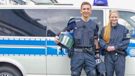 Eric als Polizist vor Polizeiauto