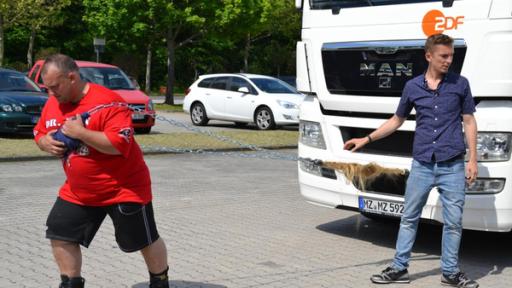 Mann zieht LKW mit Haaren.