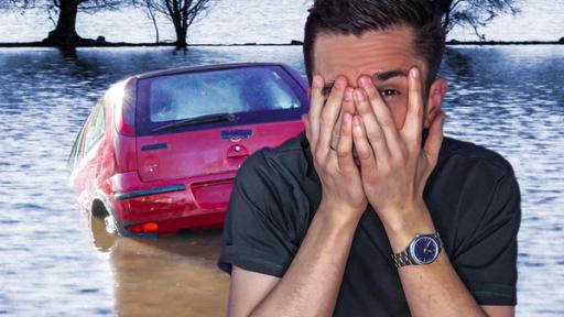 Moderator Eric Mayer ist rechts im Bild. Er hält sich die Hände vors Gesicht und schaut zwischen den Fingern angsterfüllt hindurch. Im Hintergrund sieht man, wie ein rotes Auto beginnt, im Wasser eines Flusses zu versinken.