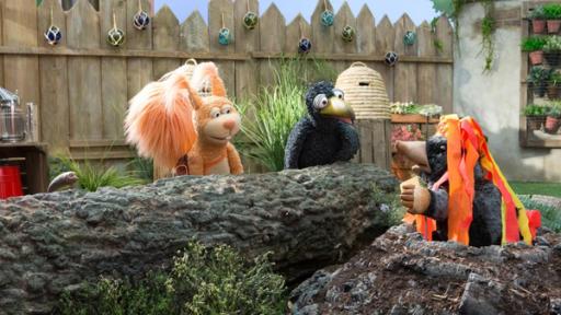 Die Schnipseljagd | Rechte: ZDF Eichhörnchen Ella und Rabe Rudi hocken vor dem Maulwurfshügel, aus dem Maulwurf Grete herausschaut. Grete trägt einen Hut mit rot-gelben Kreppbändern, die an Lavaströme erinnern.