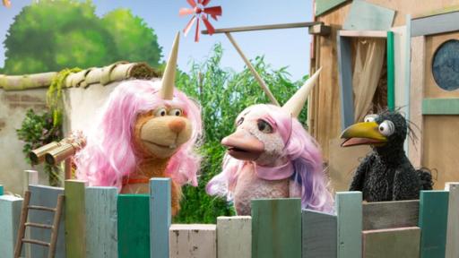 Die Superhörner (Teaser + Bühne L) | Rechte: ZDF Rabe Rudi ist auf der Baumhaus-Plattform und schaut entsetzt auf Eichhörnchen Ella und Lina. Die beiden tragen rosa Perücken und Einhorn-Hörner auf den Köpfen und scheinen Rudi nicht zu bemerken.