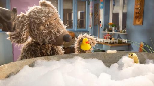 Würmer stinken | Rechte: ZDF Hund Buffo steht vor der Badewanne und hat eine Quietscheente in der Hand. Wurm Lotti sitzt in der Badewanne und badet.