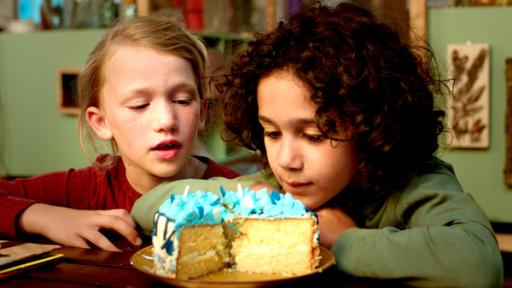 Zwei Kinder schauen auf einen blauen Kuchen