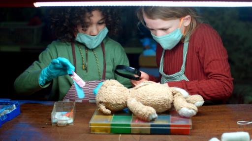 Zwei Kinder verarzten einen Teddybär