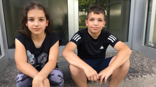 Dilara und Emre sitzen vor ihrem Haus und haben Post vom Bürgermeister bekommen. Er schreibt, dass er ihnen nicht helfen kann, weil  es zurzeit keine freien, großen Wohnungen gibt.