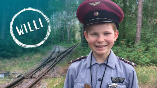Willi will Lokführer werden | Rechte: rbb Willi steht in Lokführer-Uniform an einer Gleisanlage im Wald; Text im Bild: WILLI (Quelle: rbb)
