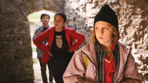 Schloss Einstein Staffel 24 | Rechte: MDR/KiKA Joyce, Finja und Paul stehen hintereinander. Sie sind umgeben von alten Mauern.