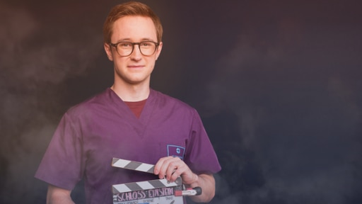 Arne Kertész (Rolle Dr. Oliver Probst) hält eine Filmklappe in die Kamera.