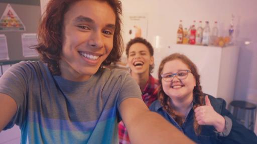 Ein Junge macht ein Selfie mit zwei Mitschülern.