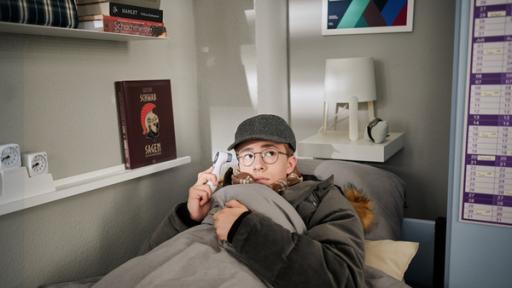 Ein Mädchen liegt dick angezogen in einem Bett.