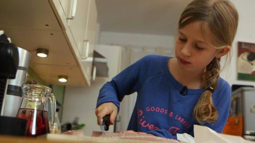 Hamburger Pannfisch kochen | Rechte: SWR Lotte steht in der Küche und schneidet den Fisch klein.