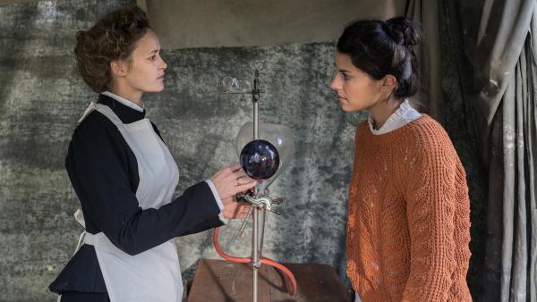 Marie Curie (Inez Bjørg David, li.) erzählt Clarissa (re.) von ihren mobilen Röntgengeräten.