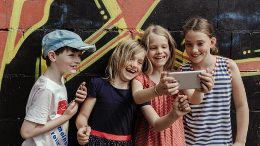 Datenschutz bei KiKA | Rechte: KiKA/Mira Mikosch Vier Kinder schauen auf ein Smartphone.