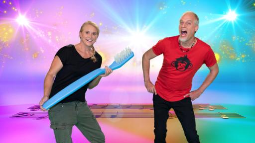 Der singende Zahn | Rechte: ZDF Singa und Andi von der Affenbande im SingAlarm Studio. Singa lacht in die Kamera und hat eine sehr große Zahnbürste in der Hand. Andi schaut in die Kamera mit offenem Mund.