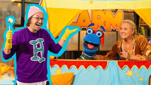 Einfach märchenhaft | Rechte: ZDF Singa und das SingDing schauen aus einer bunten Bühne für Puppenspiele hervor. Das SingDing hat eine rote Kasper-Mütze auf dem Kopf und Singa trägt ein orangebraunes Samtkleid wie eine Märchenprinzessin. Beide schauen freudig zu herrH, der vor der Bühne steht. Er trägt gelbe Putzhandschuhe und hält eine Putzbürste in der Hand. Er lacht und hat die Arme leicht ausgebreitet. Auf seinem violetten Pullover ist ein großes, türkisfarbenes „H“ abgebildet.