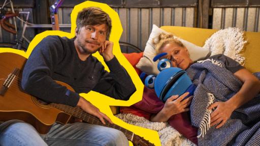 Gute Nacht | Rechte: ZDF Herr Jan (l.) hält seine Gitarre in der Hand und lehnt an einer Couch. Singa (r.) liegt mit SingDing (m.) auf der Couch und hat die Augen zu.