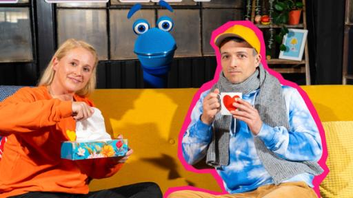 Hatschi | Rechte: ZDF Singa und Simon sagt sitzen auf dem Sofa und schauen leicht kränklich. Singa hält ein Taschentuch in der Hand und Simon eine Tasse. Hinter dem Sofa schaut das SingDing hervor.