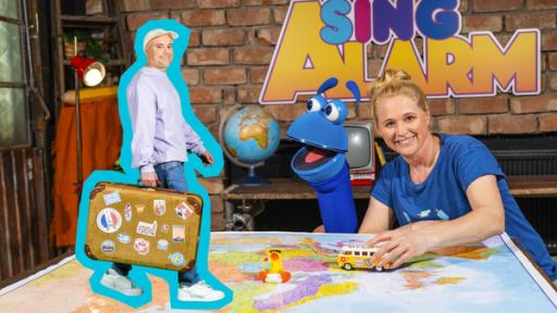 Urlaub in Europa | Rechte: ZDF Singa und das SingDing sitzen vopr einer Europakarte, über die Singa einen Spielzeugbus schiebt. Links von den beiden ist das Foto eines Mannes mit Koffer zu sehen. Hinter Singa und dem SingDing prangt der Schriftzug "SingAlarm".