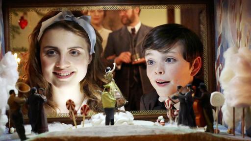Marie Stahlbaum (Mala Emde) und Fritz Stahlbaum (Leonard Seyd) schauen erstaunt in die Zuckerwelt im Hintergrund die Eltern Frau Stahlbaum (Brigitte Hobmeier) und Vater Stahlbaum (Jürgen Tonkel)