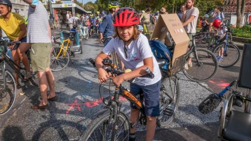Jupp - Der Fahrradaktivist | Rechte: ZDF Jupp trägt einen roten Fahrradhelm und steht an seinem Rad mitten unter vielen Radaktivisten bei der Fahrraddemo. Er trägt ein weißes T-Shirt mit Aufschrift. Die Sonne scheint. Jupp lächelt in die Kamera.