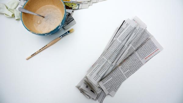 Zeitungsstreifen, Tapetenkleister und Pinsel