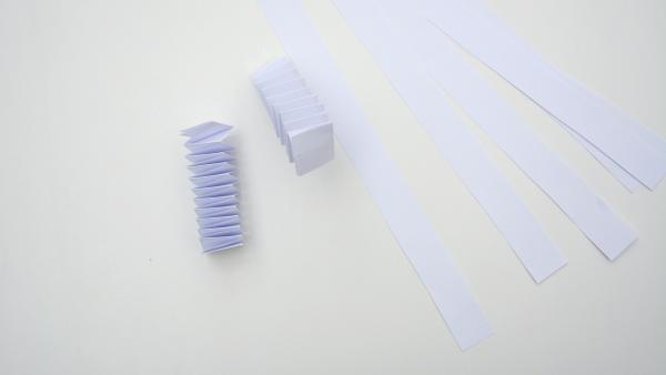 Papierstreifen und zwei aus Papierstreifen gefaltete Hexentreppen