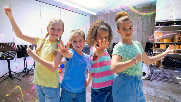 Viktoria, Nika, Lauta und Sophia stehen vor dem Musikraum. 