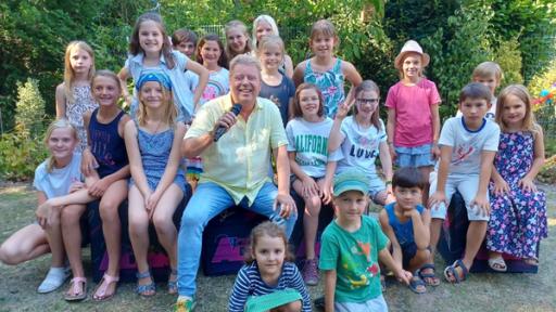 Rechte: KiKA/Anne Reichenbach Volker Rosin feiert mit Alina, Kilian und ihren Freunden eine super Gartenparty.