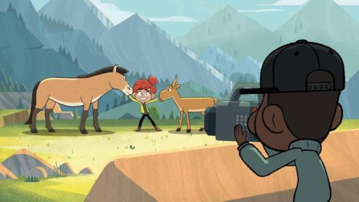 Taylor steht vor einer Bergkulisse. Links und rechts von ihr hält sie ein Pferd und einen Bock fest. Sie lächelt gekünstelt und im Vordergrund sieht man Tommy, der die Szene filmt.