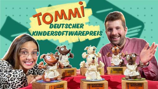 Rechte: KiKA Soraya und Tim neben einem Tisch, auf dem die TOMMI-Preise stehen. Sie haben die Gestalt von Hunden, die als Römer verkleidet sind.