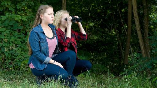 zwei Mädchen ducken sich am Wald und beobachten durch ein Fernglas | Rechte: SWR zwei Mädchen ducken sich am Wald und beobachten durch ein Fernglas