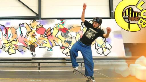 Skateboarder vor Graffiti-Leinwand