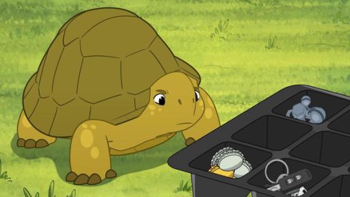 Folge 25: Geklaute Geschenke | Rechte: © Caligari Film Schildkröte Törtel steht auf dem Rasen vor einem schwarzen Kästchen mit jeder Menge glänzender Gegenstände. Dazu gehören beispielsweise Kronkorken, aber auch ein Schlüssel liegt darin. Er schaut diese mit skeptischem Blick an.