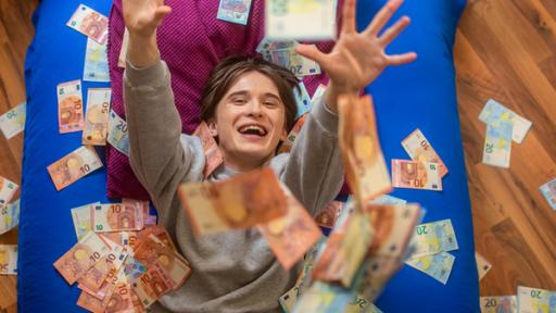 Young Crime - Teaser - Staffel 3 - Falschgeld aus dem Darknet | Rechte: ZDF Ein Junge liegt auf einer Matratze und lacht, während Geldscheine auf ihn regnen