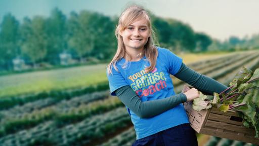 Young Gemüse Coach | Rechte: KiKA/bildpool Film- & Fernsehproduktion GmbH/Harald Mohr Ein blondes Mädchen steht auf einem Feld und hält eine Holzkiste voll frischem Gemüse im Arm. Sie trägt ein blaues T-Shirt mit der Aufschrift „Young Gemüse Coach“.